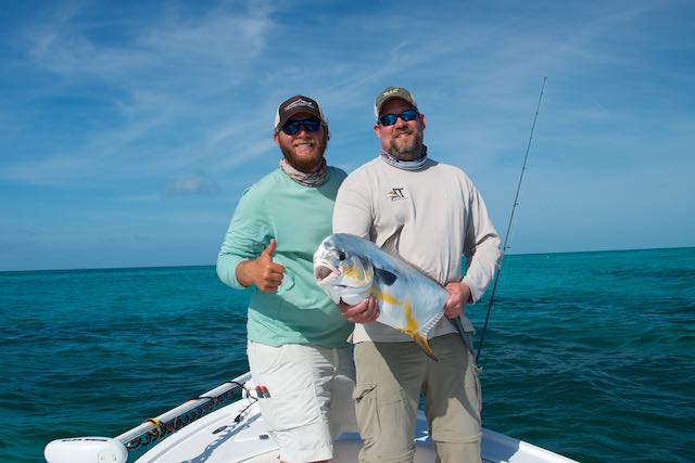 Capt. Kyle Kelso with a happy customer and his permit