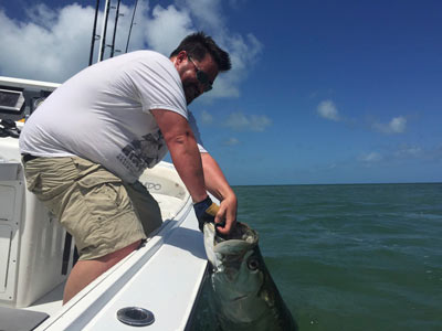 An angler posing with his shallow water Key West Tarpon